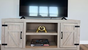 A wooden entertainment center with a flat-screen TV mounted above it. - Sweet Esmeralda-FirePit, BBQ, Pets OK, Fenced Yard (Nampa)