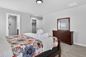 Ein Schlafzimmer mit einem Bett, einem Schminktisch, einem Spiegel und einer Tür zu einem Schrank.
