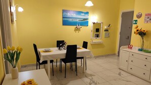 Un comedor con una mesa preparada para dos, una bicicleta y un cuadro en la pared.
