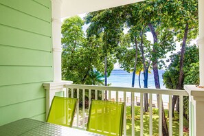 Ein Balkon mit Blick auf das Meer und Bäume.
