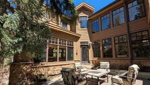 A patio with outdoor furniture and a stone wall. - Last Lift Lodge |  River Views, Grill, & Garage (Keystone)
