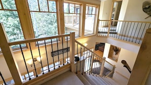 A multi-level wooden staircase with a view of a balcony and a sign indicating 'The Shelton's 39'60' T5'. - Last Lift Lodge |  River Views, Grill, & Garage (Keystone)