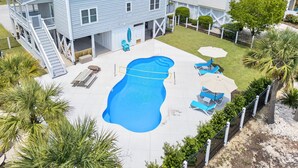Une propriété résidentielle dotée d’une piscine, d’un espace extérieur aménagé et d’une cour clôturée.
