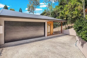 Ein modernes Haus mit Garage, überdachter Veranda und Auffahrt.