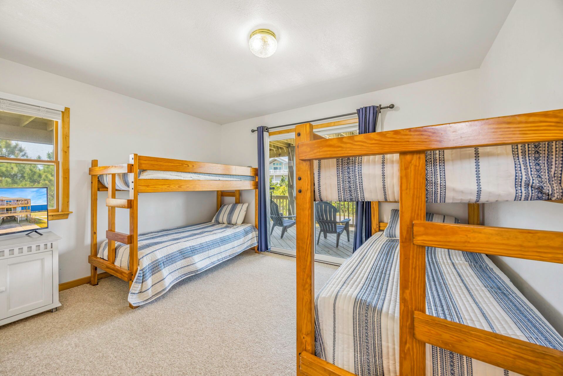 Ein Zimmer mit Etagenbetten, einem Schreibtisch und Blick auf ein Gebäude durch ein Fenster.