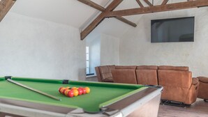 A pool table with balls, a brown sofa, and a television on the wall. - Spacious Four Bedroom Holiday Accommodation On Anglesey | Bryndeusant (Holyhead, Ynys Môn)