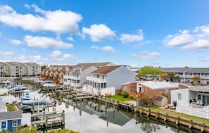 Un port de plaisance avec des bateaux amarrés, un canal et des maisons mitoyennes dotées de balcons.