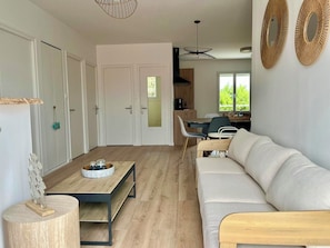 Ein modernes Wohnzimmer mit einer Couch, einem Couchtisch und einem Essbereich mit Stühlen und einem Tisch.
