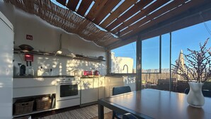 Eine moderne Küche mit großem Fenster, einem Esstisch und Blick ins Freie.