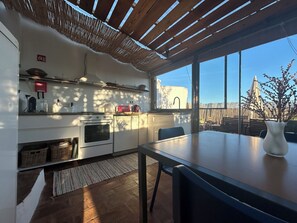A modern kitchen with a large window, a dining table, and a view of the outside. - Casa de Santa Catarina - Unique Authentic Charm (Faro)