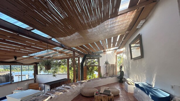 Ein modernes Interieur mit einer Steinsitzbank, einem Holztisch und Blick ins Freie.