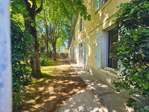 A pathway leading to a building with a row of windows, surrounded by trees and greenery. - Libourne near Saint-Émilion, Villa Beauséjour (Libourne)