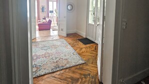 A hallway with wooden flooring, a patterned rug, a ceiling fan, and a door leading to another room. - Libourne near Saint-Émilion, Villa Beauséjour (Libourne)
