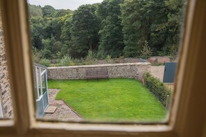 A stone wall, a grassy yard, and a bench. - Palace Garden Cottage (Bishop Auckland)
