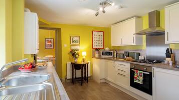 A kitchen with a sink, stove, microwave, and cabinets.