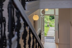 Una escalera que conduce a un acceso con vistas a un jardín.