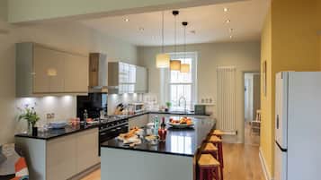 A modern kitchen with a central island, built-in appliances, and pendant lighting.