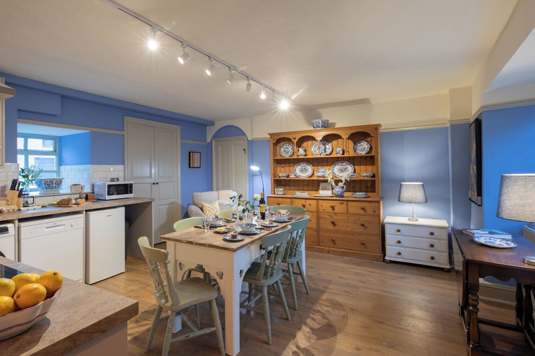 A kitchen with a dining area, wooden cabinets, and a microwave.