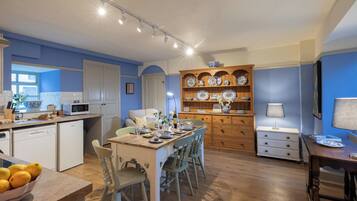 A kitchen with a dining area, wooden cabinets, and a microwave.