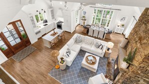 A spacious loft-style interior with a kitchen, dining area, and living room, featuring high ceilings and large windows. - Charming cottage in popular neighborhood (Kiawah Island)