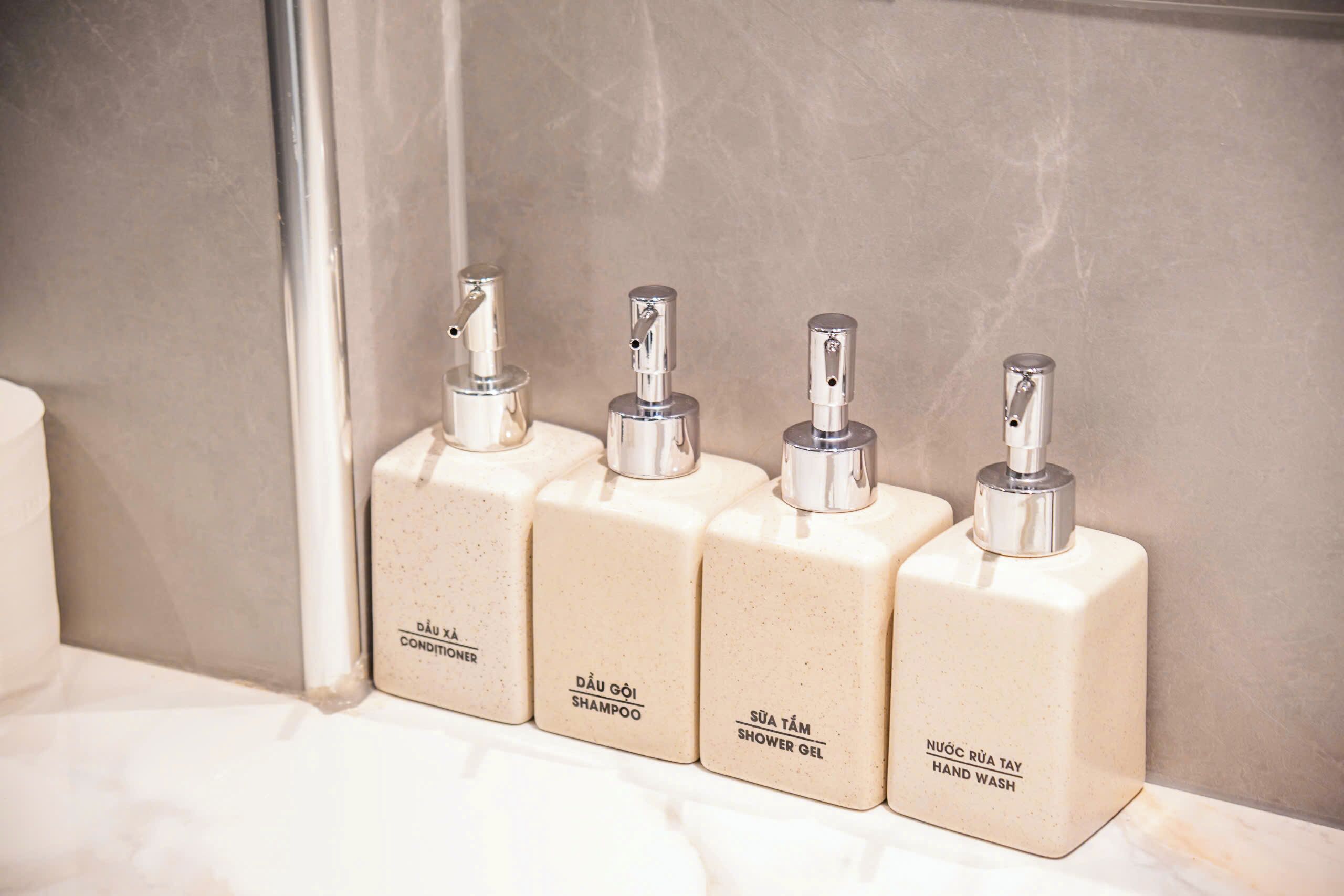 Four toiletry bottles on a bathroom counter.