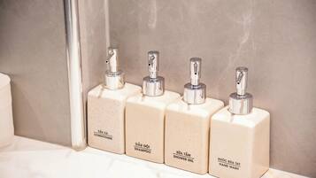 Four toiletry bottles on a bathroom counter.