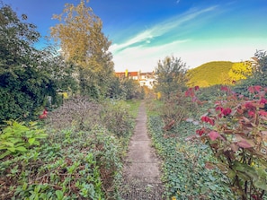 Ein Gartenweg führt zu einem Gebäude mit einer gelben Mauer.