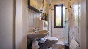 A bathroom with a sink, toilet, and shower. - ImmoStay-bright apartment with private garden #1 (Bremen)