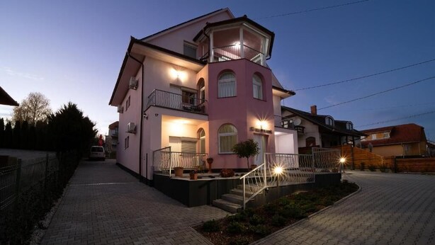 A multi-story residential building with a balcony, a staircase, and a paved driveway. - VILLA LOTUS PANZIÓ (Zalakaros)