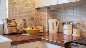 A kitchen with a microwave, kettle, and a coffee maker on the counter. - Sheriff's Tower Cottage - West (Bishop Auckland)