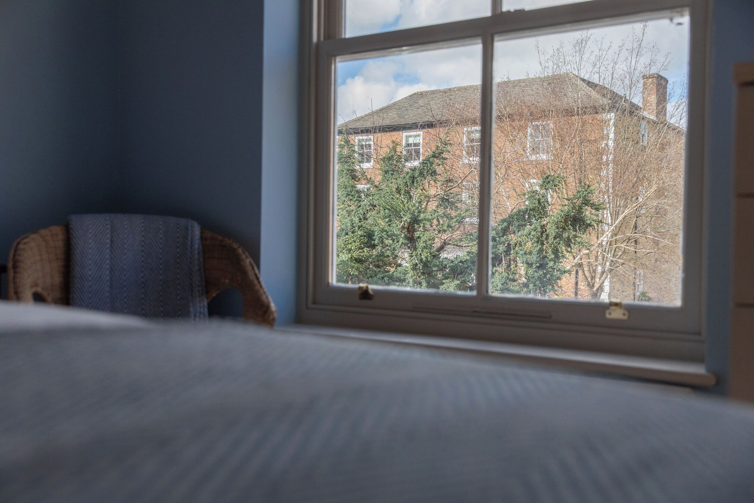 A room with a window, a bed, and a chair.