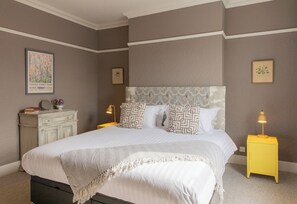 A bedroom with a bed, a nightstand, a dresser, and a framed picture on the wall. - No 2 Townhouse (Bishop Auckland)
