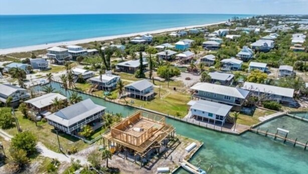 A coastal residential area with houses, a dock, and a clear view of the ocean. - Welcome to Waters Edge, a true hidden gem on Little Gasparilla Island-where turquoise water, gentle breezes, and total relaxation replace traffic, noise, and stress (Placida)