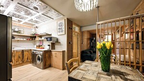Eine moderne Küche mit Holzausstattung, einem Geschirrspüler und einem Essbereich mit Tisch und Stühlen.