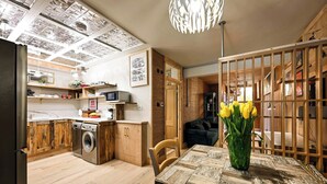 Eine moderne Küche mit Holzausstattung, einem Geschirrspüler und einem Essbereich mit Tisch und Stühlen.