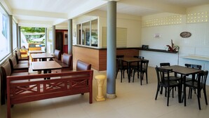 Un restaurante con cabinas, mesas y una barra.