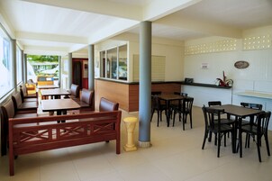 Um restaurante com cabines, mesas e balcão.