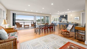 Amplia sala de estar con comedor, cocina y vista a un cuerpo de agua.
