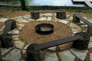 A circular stone fire pit with benches around it.