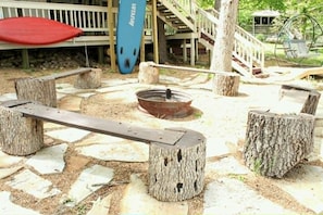 A wooden bench with a metal frame, surrounded by tree stumps.