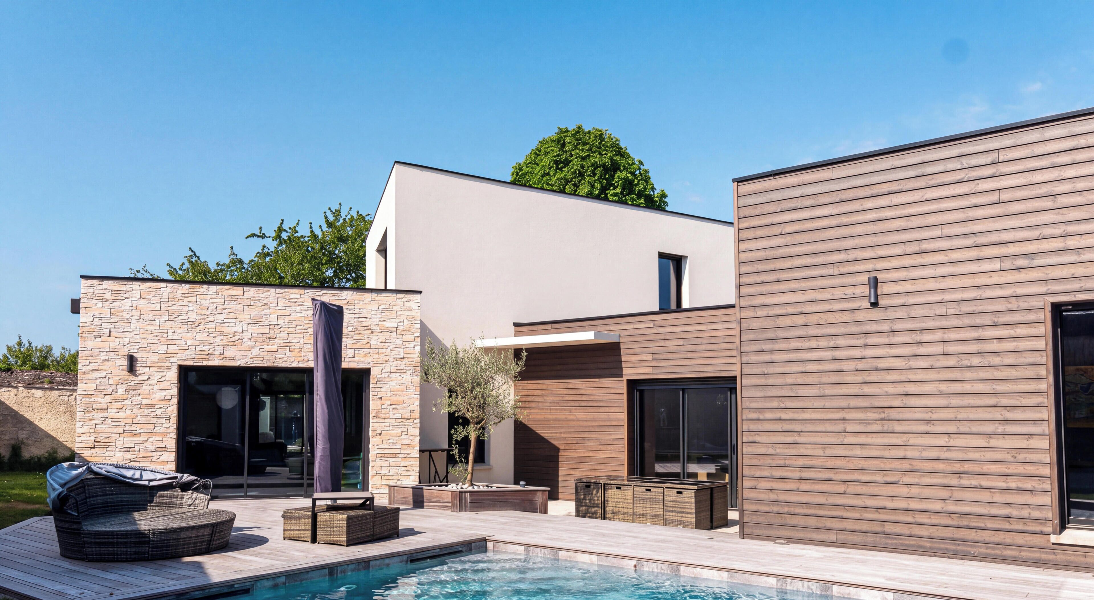 Una casa moderna con piscina, mobiliario exterior y un gran árbol.