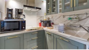 Cozinha equipada com micro-ondas, máquina de café e pia.