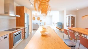 A modern kitchen with a central island, stainless steel appliances, and a hanging light fixture. - Villa Brisamar Azul | Caleta de Fuste | Golf Views | Heated Pool | Near Beach (Fuerteventura)