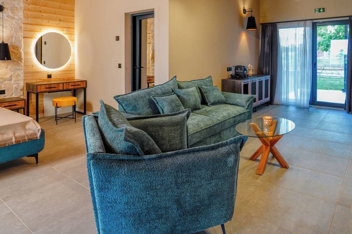 Ein modernes Wohnzimmer mit einer Couch, einem kleinen Tisch, einem Schreibtisch und einem Spiegel.