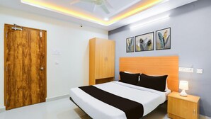 Un dormitorio con cama, armario de madera, mesita de noche, ventilador de techo y un cuadro en la pared.