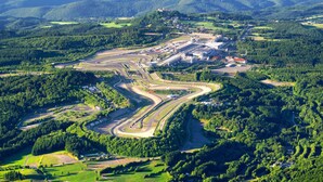 Vista aèria d'una pista de cursa envoltada per turons verds i boscos frondosos.