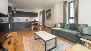 Una sala moderna con sofá, mesa de centro y comedor con sillas y mesa.