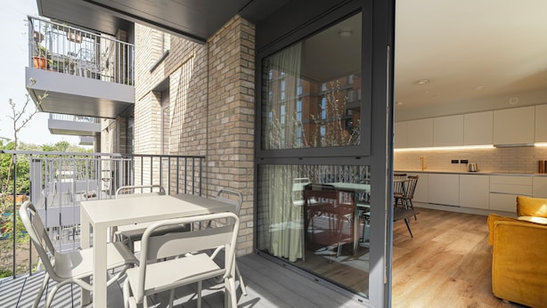 Un apartamento moderno con balcón, comedor y cocina.