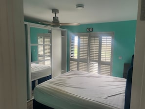 A bedroom with a bed, a ceiling fan, and a window with blinds. - A little slice of heaven! (Rosmuc)