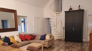 A living room with a sofa, coffee table, and a staircase. - A little slice of heaven! (Rosmuc)
